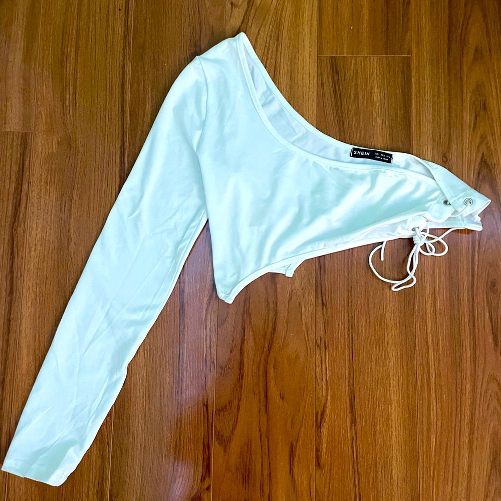 It’s a small white crop top, one sleeve with strings to tie. kinda revealing.